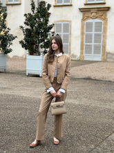 a lady in a brown round neck single-breasted crop jacket